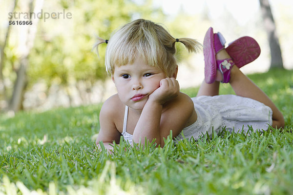 Kleines Mädchen auf Gras liegend  Portrait