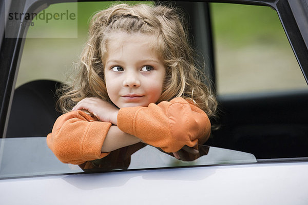 Kleines Mädchen aus dem Autofenster gelehnt  Portrait