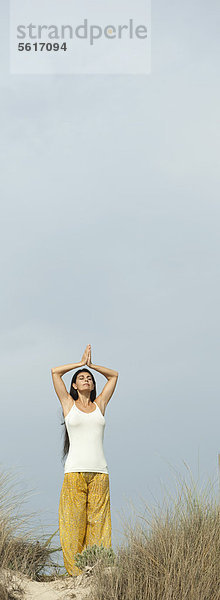 Reife Frau beim Gebet Yoga-Position am Strand