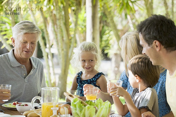 Mehrgenerationen-Familie beim Frühstück im Freien