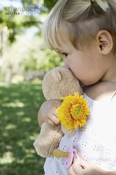 Kleines Mädchen mit Teddybär  Blume und Schnuller