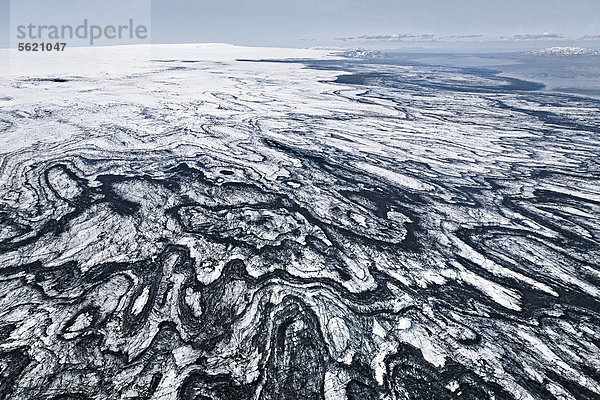 Luftaufnahme von Linien und Strukturen aus Vulkanasche und schwarzer Lava im Eis und Schnee des Vatnajökull Gletschers in Island  Europa