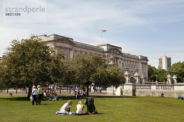 Touristen pausieren auf der Wiese vor dem Buckingham Palace  London  England  Großbritannien  Europa