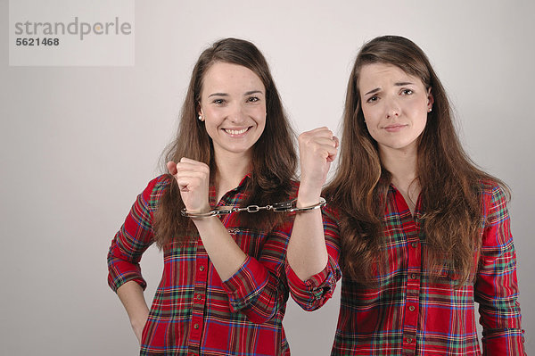 Zwillingsschwestern  mit Handschellen aneinander gekettet