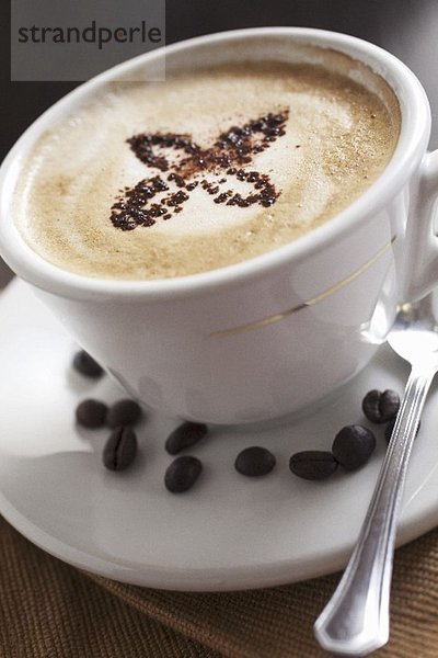 Cappuccino und Kaffeebohnen