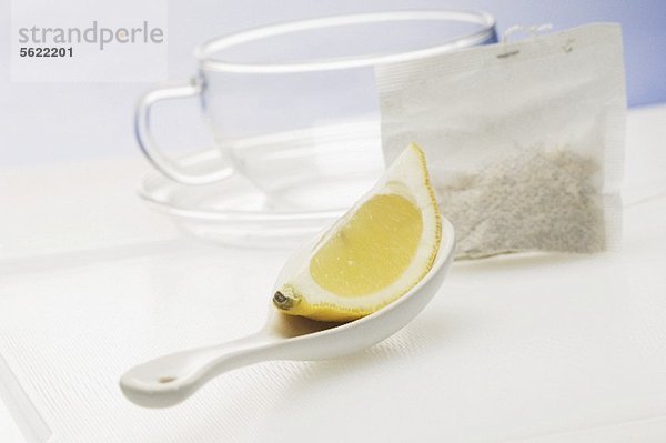 Zitronenschnitz auf Löffel  Teebeutel und Teetasse
