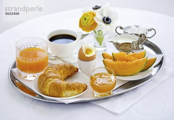 Frühstück mit Melone  Croissant  Ei  Marmelade  Kaffee und Orangensaft