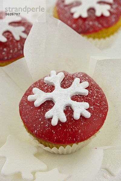 Cupcake mit roter Zuckerglasur und einer Schneeflocke