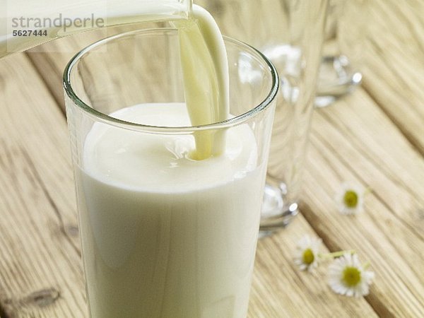 Milch in ein Glas einschenken