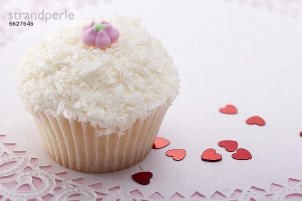 Cupcake mit Kokosraspeln und Zuckerblüte