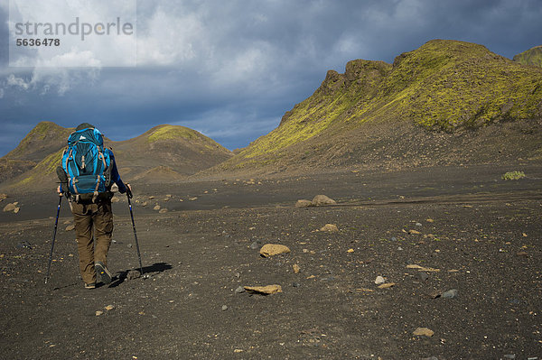 Wanderin in der schwarzen Lavawüste und mit Moos bedeckte Berge am Wanderweg Laugavegur  ¡lftavatn-Emstrur  Hochland  Island  Europa