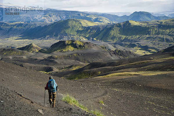 Blick auf Gletscher M_rdalsjökull  Wanderin in der schwarzen Lavawüste und mit Moos bedeckte Berge am Wanderweg Laugavegur  ¡lftavatn-Emstrur  Hochland  Island  Europa