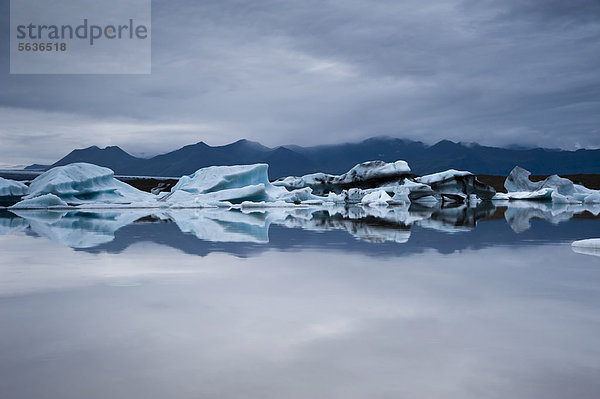 Blaue und von Asche schwarz gefärbte Eisberge  Spiegelung  Gletscherlagune Brei_·rlÛn  Breidarlon  Vatnajökull Gletscher  Austurland  Ost-Island  Island  Europa