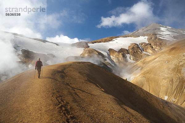 Wanderin auf dem Wanderweg  heiße Quellen und mit Schnee bedeckte Rhyolith-Berge  Hochtemperaturgebiet Hveradalir  Kerlingarfjöll  Hochland  Island  Europa
