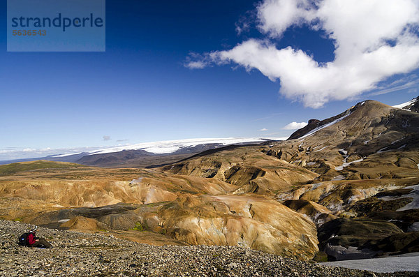 Wanderin rastet auf dem Wanderweg und betrachtet Rhyolith-Berge  Hochthermalgebiet Hveradalir  Kerlingarfjöll  Hochland  Island  Europa