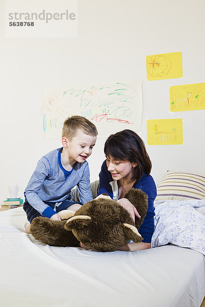 Mutter und Sohn spielen auf dem Bett