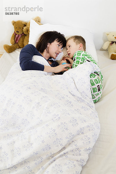 Mutter und Sohn im Bett liegend