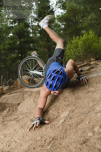 Mann fällt vom Mountainbike