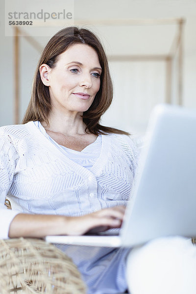 Frau mit Laptop im Sessel