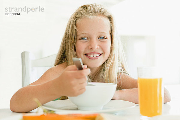 Mädchen essen Müsli am Frühstückstisch