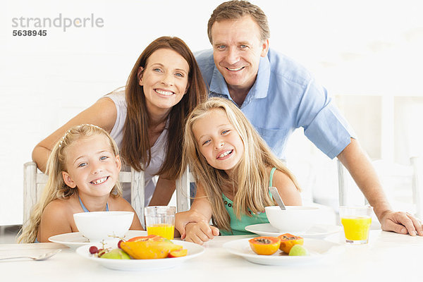 Familie lächelt am Frühstückstisch