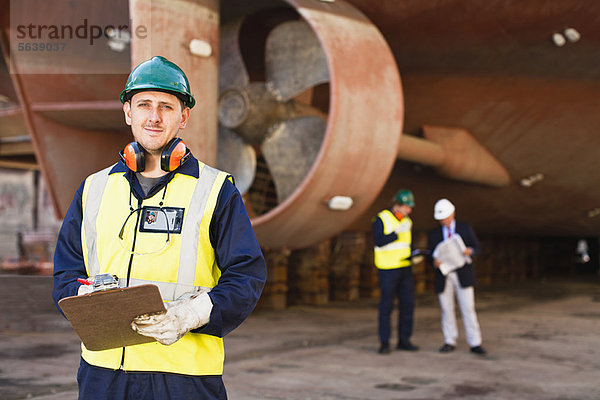 Arbeiter mit Klemmbrett auf dem Trockendock