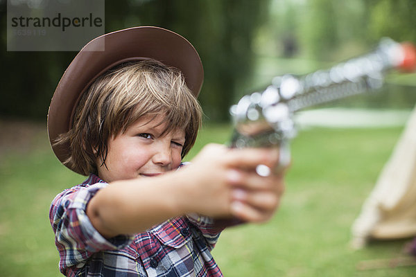 Junge im Cowboyhut mit Spielzeugpistole
