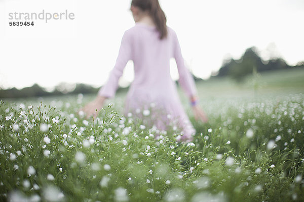 Mädchen beim Spaziergang im Blumenfeld