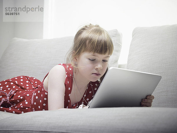 Mädchen mit Tablet-Computer auf dem Sofa