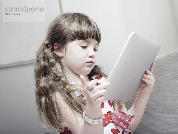 Mädchen mit Tablet-Computer auf dem Sofa