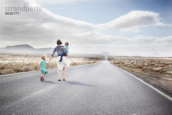 Familienwanderung auf gepflasterter Landstraße