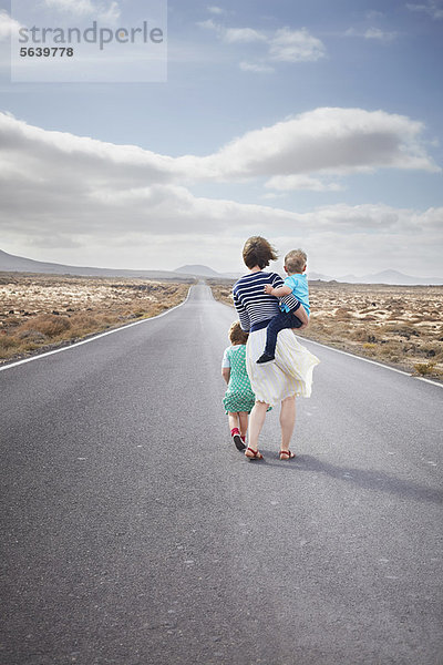 Familienwanderung auf gepflasterter Landstraße