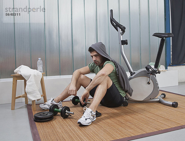 sitzend  Fitness-Studio  Mann  Boden  Fußboden  Fußböden  zu Hause