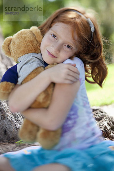 Mädchen umarmender Teddybär