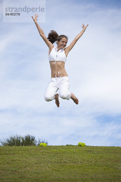 Mädchen beim Springen in der Luft im Feld