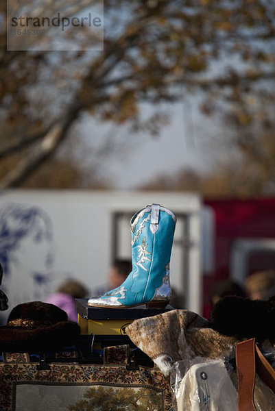 Ein blauer Cowboystiefel auf einem Flohmarkt