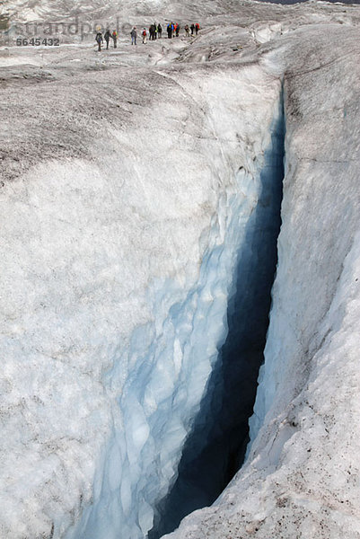 Eine Gletscherspalte im Aletschgletscher  Schweiz  Wanderer im Hintergrund