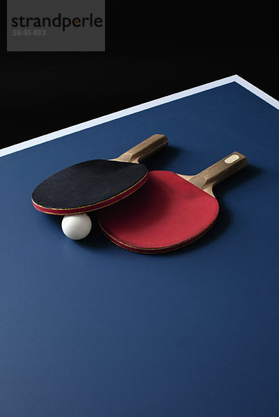 Tischtennisschläger und ein Ball auf einem Tisch