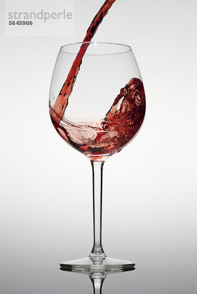 Rotwein wird in ein Glas gegossen