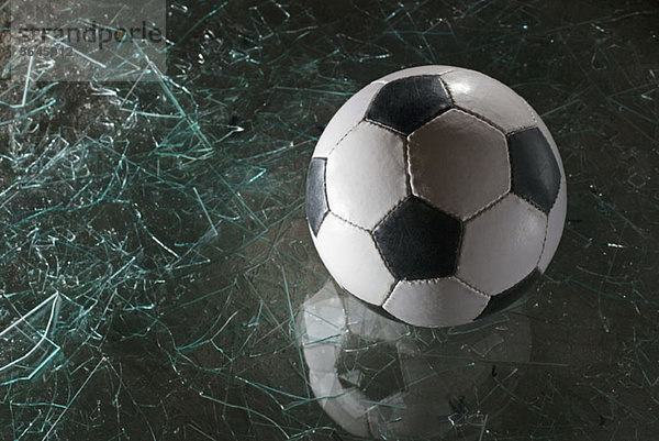Ein Fußball auf zerbrochenem Glas