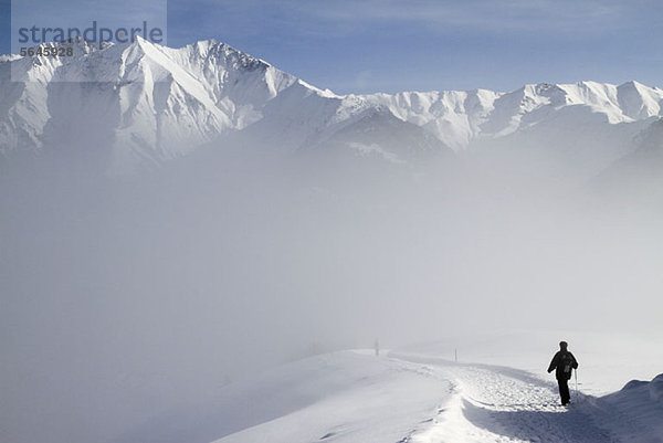 Wandern auf dem Weg durch die verschneite Bergkette