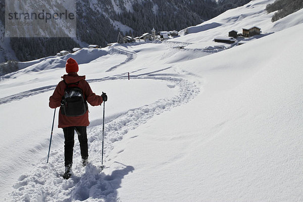 Wanderer auf dem Weg zum verschneiten Dorf