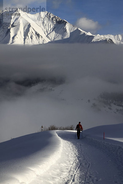 Wanderer wandern Schneewanderweg mit Blick auf die Bergkette im Hintergrund