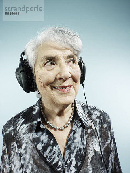 Eine ältere Frau mit Kopfhörer