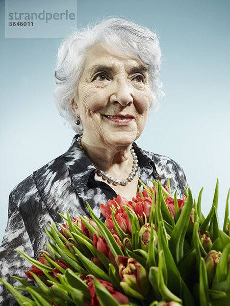 Eine ältere Frau  die einen Strauß Tulpen erhält.