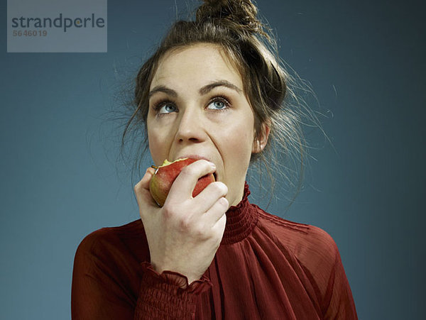 Eine junge Frau  die einen Apfel isst.