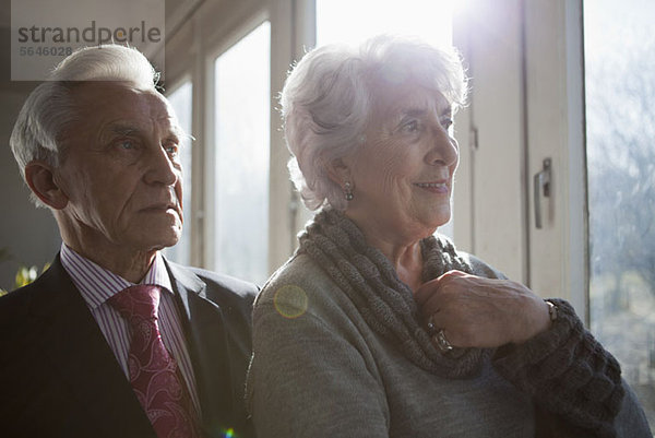 Ein älteres Paar schaut aus dem Fenster auf die Aussicht.