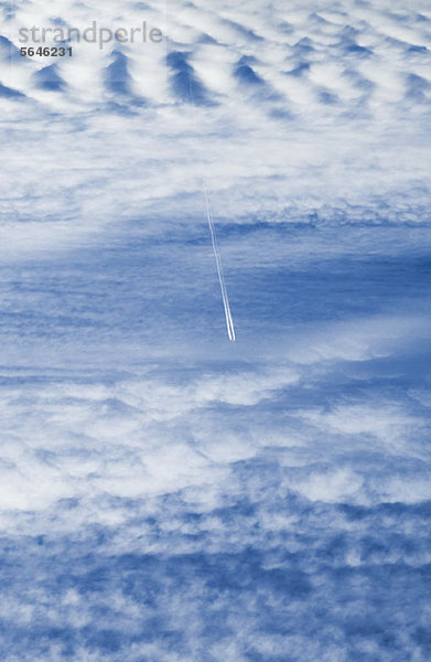 Plane Kondensstreifen über Wolkenlandschaft