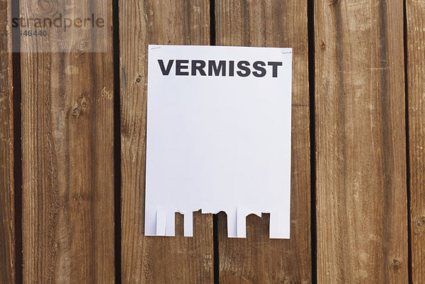 Ein Flyer auf einem Holzzaun mit dem deutschen Wort für vermisst .