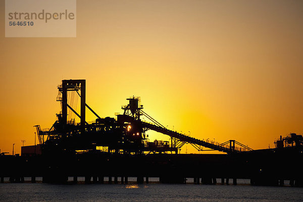 Silhouette eines Schaufelradrückladers in einer Eisenerzmine